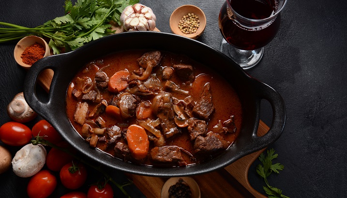 Beef Bourguignon in a pan. Stew with red wine ,carrots, onions, garlic, a bouquet garni, and garnished with pearl onions,